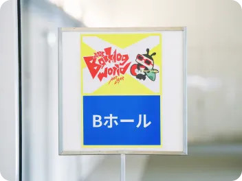 BacklogWorld 2025イベント会場の案内サイン。「Bホール」という青い表示の上に、「Backlog World 2025」のロゴが掲示されている。
